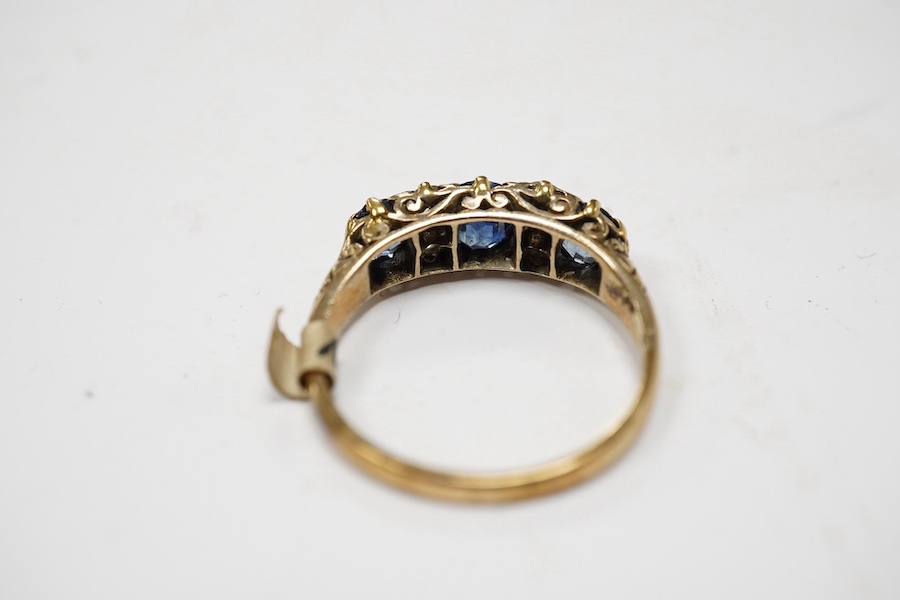 A yellow metal and three stone sapphire and four stone diamond set half hoop ring, size P/Q, gross weight 3.3 grams. Condition - poor to fair